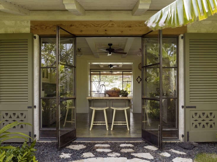 in an indoor/outdoor hawaiian house, double doors open from kitchen to gravel c 30